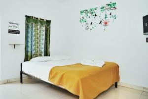 a bedroom with a bed with a yellow blanket on it at Paradise Feel Dreamy Resort in Puducherry