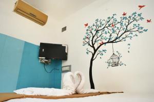 un dormitorio con un árbol con una jaula de pájaro en la pared en Paradise Feel Dreamy Resort en Pondicherry