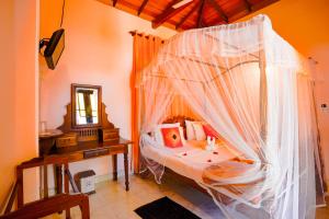 a bedroom with a bed with a mosquito net at Frangipani motel in Galle