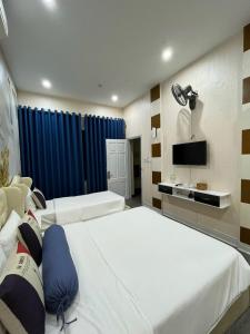 a hotel room with two beds and a television at Khách sạn Hướng Dương in Hanoi