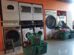 a laundry room with two washers and two drying racks at Autumn Living Hotel in Surabaya