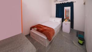 Natureland Homestay في كوتايم: غرفة نوم صغيرة مع سرير ومرآة