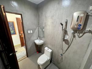 a bathroom with a shower and a toilet and a sink at Fat Lips Surf Lodge in General Luna