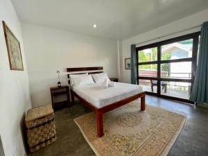 a bedroom with a bed and a large window at Fat Lips Surf Lodge in General Luna