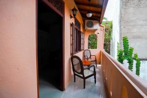 a balcony with two chairs and a table on a building at Frangipani motel in Galle