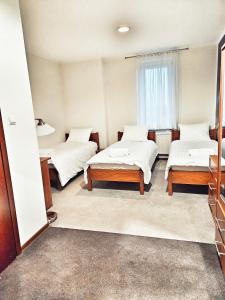 a room with three beds and a window at Hotel Max in Luboń