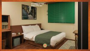 a bedroom with a bed and a green window at Jeonju AANK Hotel in Jeonju