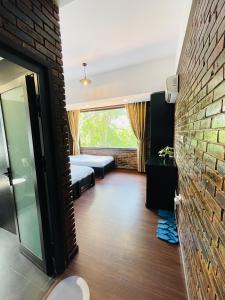 uma sala com uma parede de tijolos e um quarto em Mandarin Homestay Hue em Hue