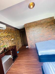 um quarto com duas camas e uma parede de tijolos em Mandarin Homestay Hue em Hue