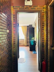 a hallway with a brick wall and an open door at Mandarin Homestay Hue in Hue