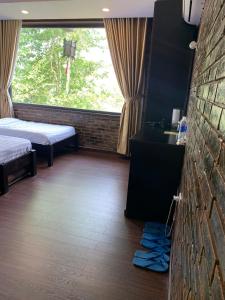 Cette chambre comprend 2 lits et un mur en briques. dans l'établissement Mandarin Homestay Hue, à Hue