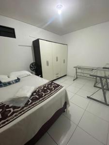 - une chambre avec un lit et une table dans l'établissement Temporada CG - Apartamento no Alto Branco, à Campina Grande