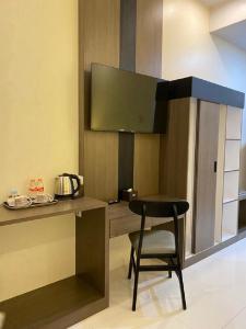 a black chair sitting in a kitchen with a counter at Genio Syariah Hotel Solo in Tjolomadu