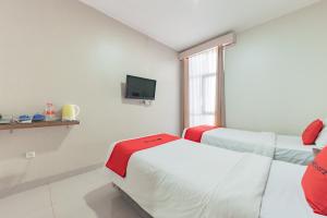 a hospital room with two beds and a tv at RedDoorz near Pasar Baru Bandung in Bandung