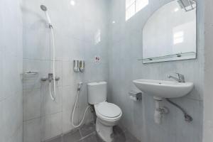 a white bathroom with a toilet and a sink at RedDoorz near Pasar Baru Bandung in Bandung