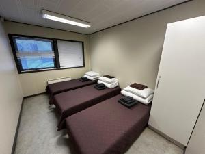 a room with three beds and a window at Nakvynes namelis in Norgėlai