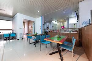 un restaurante con sillas azules y mesas. en RedDoorz near Pasar Baru Bandung, en Bandung