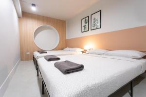 duas camas num quarto com um espelho na parede em A1 Duplex large room wt kitchen em Bangkok