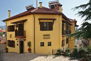 una casa amarilla con techo rojo en Villa Filoxenia Arahova en Arachova
