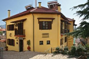a yellow house with a red roof at Rigas Hotel Arachova in Arachova