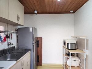 a kitchen with a refrigerator and a microwave on a shelf at Wolamjae in Gyeongju