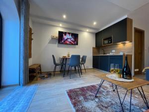 a living room with a table and a kitchen at Apartment & Studio Forest Paradise in Cerkno