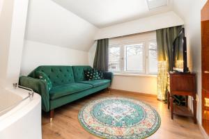 a living room with a green couch and a rug at Cozy private house in Nõmme in Tallinn