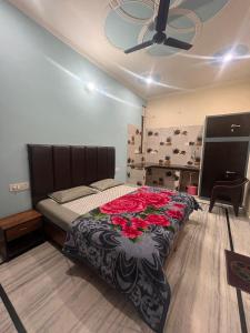Un dormitorio con una cama con rosas rojas. en Deepak Homestay, en Rishīkesh