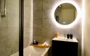 bagno con vasca, lavandino e specchio di Take your time a Cluses