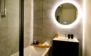 uma casa de banho com uma banheira, um lavatório e um espelho. em Take your time em Cluses