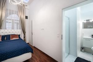 um quarto com uma cama, um lavatório e um espelho em Opera Balkony Luxury Apartment em Budapeste