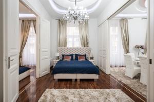 a bedroom with a blue bed and a chandelier at Opera Balkony Luxury Apartment in Budapest