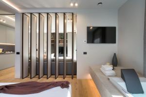 een slaapkamer met een bed en een tv aan de muur bij Aera Luxury Suites - 301 302 in Catania