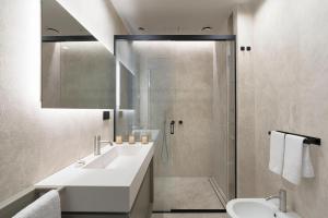 een witte badkamer met een wastafel en een douche bij Aera Luxury Suites - 301 302 in Catania