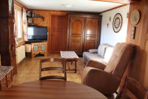 ein Wohnzimmer mit einem Sofa und einem Tisch in der Unterkunft Chalet Le Slalom in Arveyes