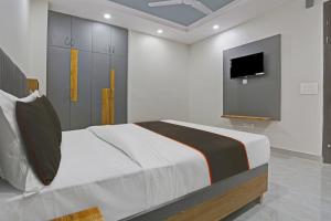 a bedroom with a bed and a flat screen tv at OYO Flagship 81411 Hotel Vip Grand in New Delhi