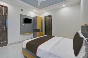 a bedroom with a bed and a tv on the wall at OYO Flagship 81411 Hotel Vip Grand in New Delhi