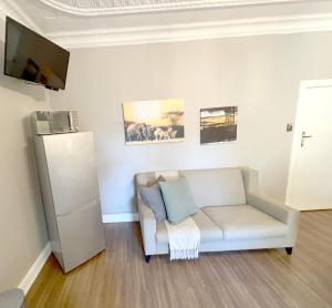 a living room with a white couch and a refrigerator at Buffels Place in Pretoria