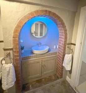 a bathroom with a sink and a brick arch at Buffels Place in Pretoria
