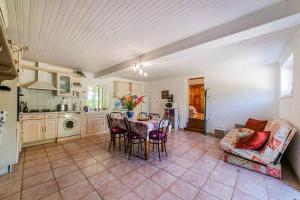 una cucina e una sala da pranzo con tavolo e sedie di Le Cayroux - Clévacances 3 clés a Blanquefort-sur-Briolance 1 altra foto