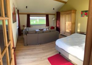a bedroom with a couch and a bed in a room at B&B - Ter Douve in Dranouter