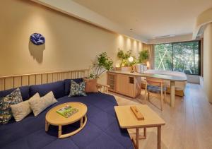 a living room with a blue couch and a tub at Fufu Karuizawa Yokou No Kaze in Karuizawa