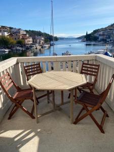 d'une table en bois et de deux chaises sur un balcon. dans l'établissement Adriana Zaton, à Zaton