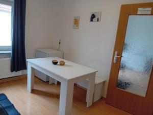 a white table in a room with a door at Stellas Monteurwohnungen in Werdau