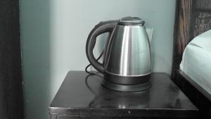 a tea kettle sitting on top of a nightstand at Lakshay Regency in Shimla
