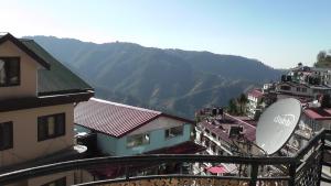 vistas a una ciudad con montañas en el fondo en Lakshay Regency en Shimla