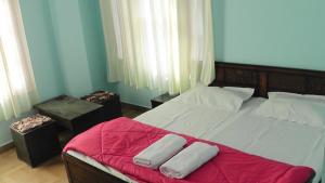 a bedroom with a bed with a red blanket on it at Lakshay Regency in Shimla