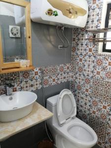 La salle de bains est pourvue de toilettes blanches et d'un lavabo. dans l'établissement Ba Vì Madela, à Ba Vì