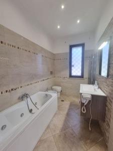 La salle de bains est pourvue d'une baignoire, de toilettes et d'un lavabo. dans l'établissement Ottimo appartamento alle porte di Roma!, à Rome