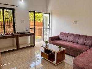 - un salon avec un canapé et une table dans l'établissement Arzu Homes, à Anjuna